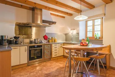 a large kitchen with a wooden table and a tableablish at Maso Via Vecchia in Ora/Auer
