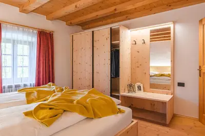 a bedroom with a bed with a yellow blanket on it at Maso Via Vecchia in Ora/Auer
