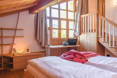 a bedroom with a bed and a stair case at Maso Via Vecchia in Ora/Auer