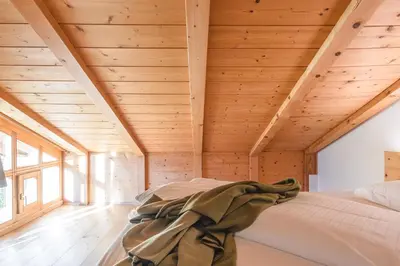 a room with a bed in a wooden house at Maso Via Vecchia in Ora/Auer