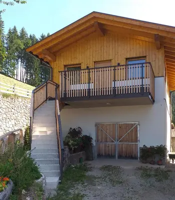 a house with a staircase and a balcony at Reitererhof in Hafling