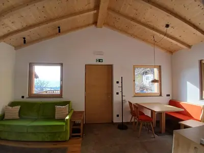 a living room with a green couch and a table at Reitererhof in Hafling