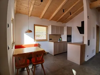 a kitchen with a wooden table and chairs and a counter at Reitererhof in Hafling