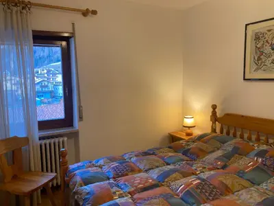 a bedroom with a bed and a window at Appartamento Casa Latemar in Predazzo