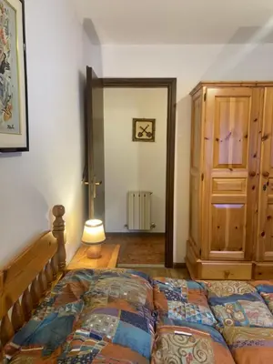 a bedroom with a bed and a door to a hallway at Appartamento Casa Latemar in Predazzo
