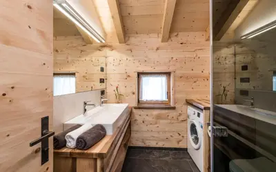 a bathroom with a sink and a washing machine at Großplonerhof in Luson