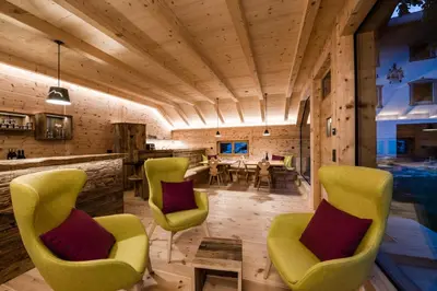 a living room with yellow chairs and a table at Großplonerhof in Luson