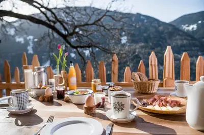 a table with food on it with a view of a mountain at Großplonerhof in Luson