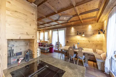 a kitchen and living room with wooden walls and ceilings at Casa Maddalena, quiet and very comfortable in Cortina dʼAmpezzo