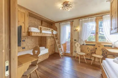 a bedroom with a bunk bed and a desk and a room at Casa Maddalena, quiet and very comfortable in Cortina dʼAmpezzo