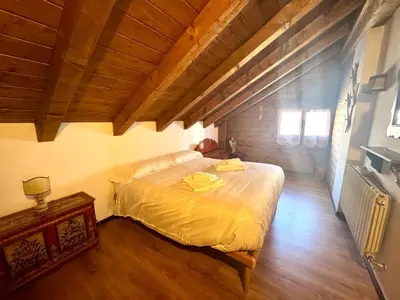 a bedroom with a bed and a wooden ceiling at Ca Novella Apartment in San Vito di Cadore