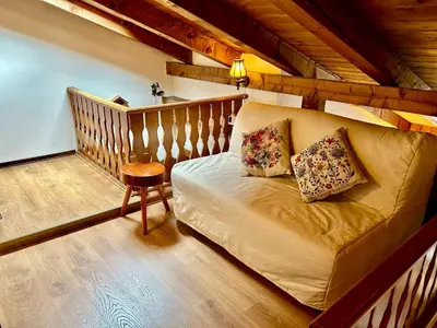 a living room with a couch and a stool at Ca Novella Apartment in San Vito di Cadore