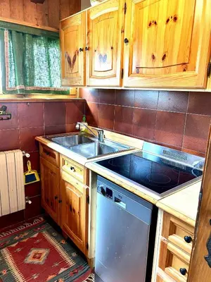 a kitchen with wooden cabinets and a sink at Ca Novella Apartment in San Vito di Cadore