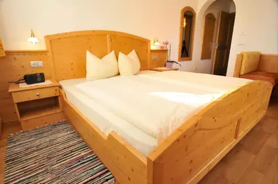 a bedroom with a wooden bed with a wooden frame at Prantschurhof in San Pietro in Gardena