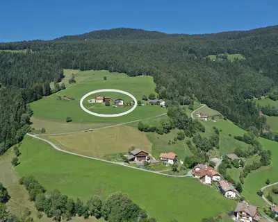 an overhead view of a house on a green field at Prantschurhof in San Pietro in Gardena