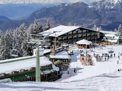 a ski lodge in the snow with people on the slopes at Eurotel Cermis in Cavalese