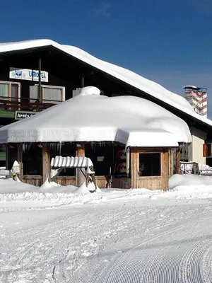 a snow covered building with a snow covered roof at Eurotel Cermis in Cavalese