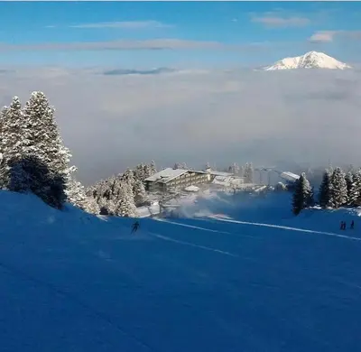 a ski resort in the snow with a snow covered mountain at Eurotel Cermis in Cavalese