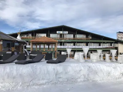 a building with chairs in the snow in front of it at Eurotel Cermis in Cavalese