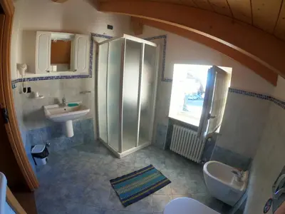 a bathroom with a shower and a sink at Appartamento Agritur nel Verde in Brez