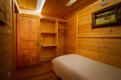 a bedroom with a bed in a log cabin at Dolomiti Urban Lodge - casa Civetta in Cencenighe