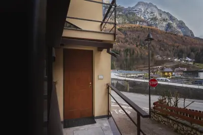 a building with a door and a stop sign at Dolomiti Urban Lodge - casa Civetta in Cencenighe