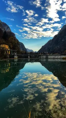 a large body of water with mountains in the background at Dolomiti Urban Lodge - casa Civetta in Cencenighe
