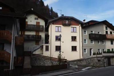 two white buildings with balconies on the side of a street at Dolomiti Urban Lodge - casa Civetta in Cencenighe
