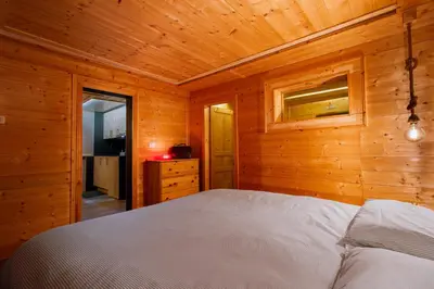 a bedroom with a bed in a wooden room at Dolomiti Urban Lodge - casa Civetta in Cencenighe