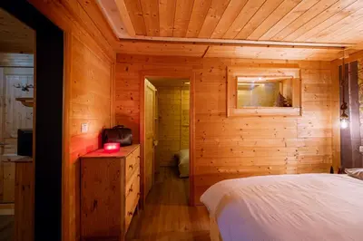 a bedroom with a bed in a wooden cabin at Dolomiti Urban Lodge - casa Civetta in Cencenighe