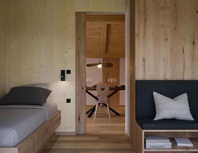 a bedroom with a bed and a table with a chair at Gfohlerhof Brixen - Urlaub auf dem Bauernhof in Brixen