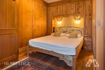 a bedroom with a bed in a room with wooden walls at Suite Villa Francesca in Cortina dʼAmpezzo