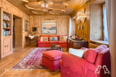 a living room with red couches and a rug at Suite Villa Francesca in Cortina dʼAmpezzo