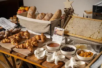 a table with various types of bread and croissants at Rifugio Cereda - Dormitory in San Martino di Castrozza