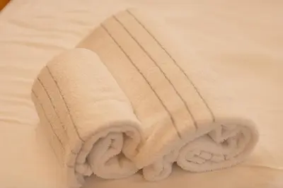 a room with a bed with towels on it at Appartamenti Dolomites Elements in Caprile
