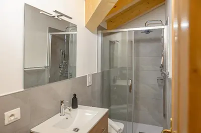 a shower with a glass door in a bathroom at Appartamenti Dolomites Elements in Caprile