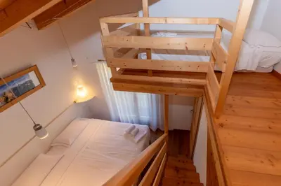 a small room with a bunk bed and a ladder at Wonderful appartment Monte Civetta in Dolomites in Alleghe