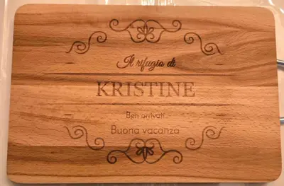 a wooden cutting board with a name on it at Rifugio Kristine in Falcade