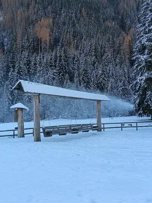 a snow covered field with a large shadow of a mountain at Rifugio Kristine in Falcade