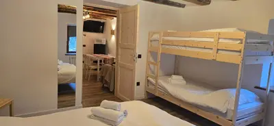 a room with a microwave and a refrigerator with a tv on the wall at Rifugio Kristine in Falcade