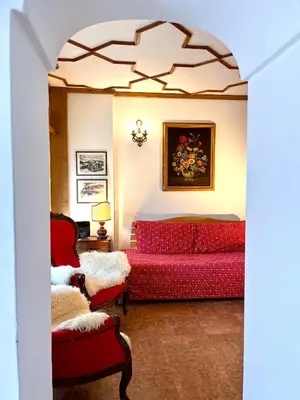 a living room with a red couch and a bed at Cortina Relax in Cortina dʼAmpezzo