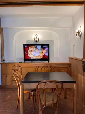 a dining room with a table and a tv at Cortina Relax in Cortina dʼAmpezzo