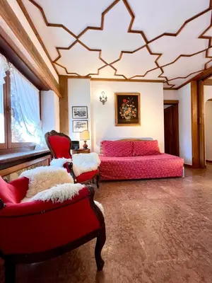 a bedroom with a bed and two chairs at Cortina Relax in Cortina dʼAmpezzo