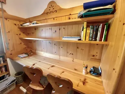 a wooden book shelf with books on it at Charming ground floor flat with mountain views in Cortina dʼAmpezzo