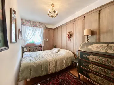 a bedroom with a bed and a dresser and a window at Charming ground floor flat with mountain views in Cortina dʼAmpezzo