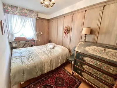 a bedroom with a bed and a dresser and a window at Charming ground floor flat with mountain views in Cortina dʼAmpezzo