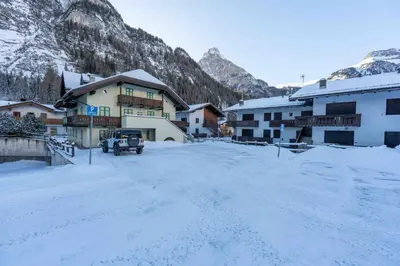 a snow covered parking lot in front of a building at Cesa Vivi in Canazei