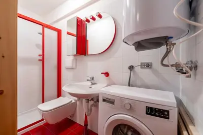 a bathroom with a washing machine and a sink at Cesa Vivi in Canazei