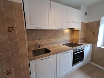 a kitchen with white cabinets and a sink at La Casa di Elvira-Primo Piano in Alleghe