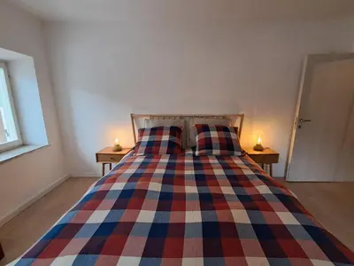 a bedroom with a bed with a colorful blanket at La Casa di Elvira-Primo Piano in Alleghe